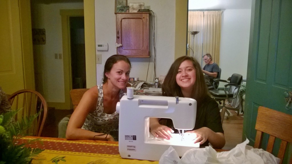 Ariana Altieri showing Maya Mendoza how to use the sewing machine